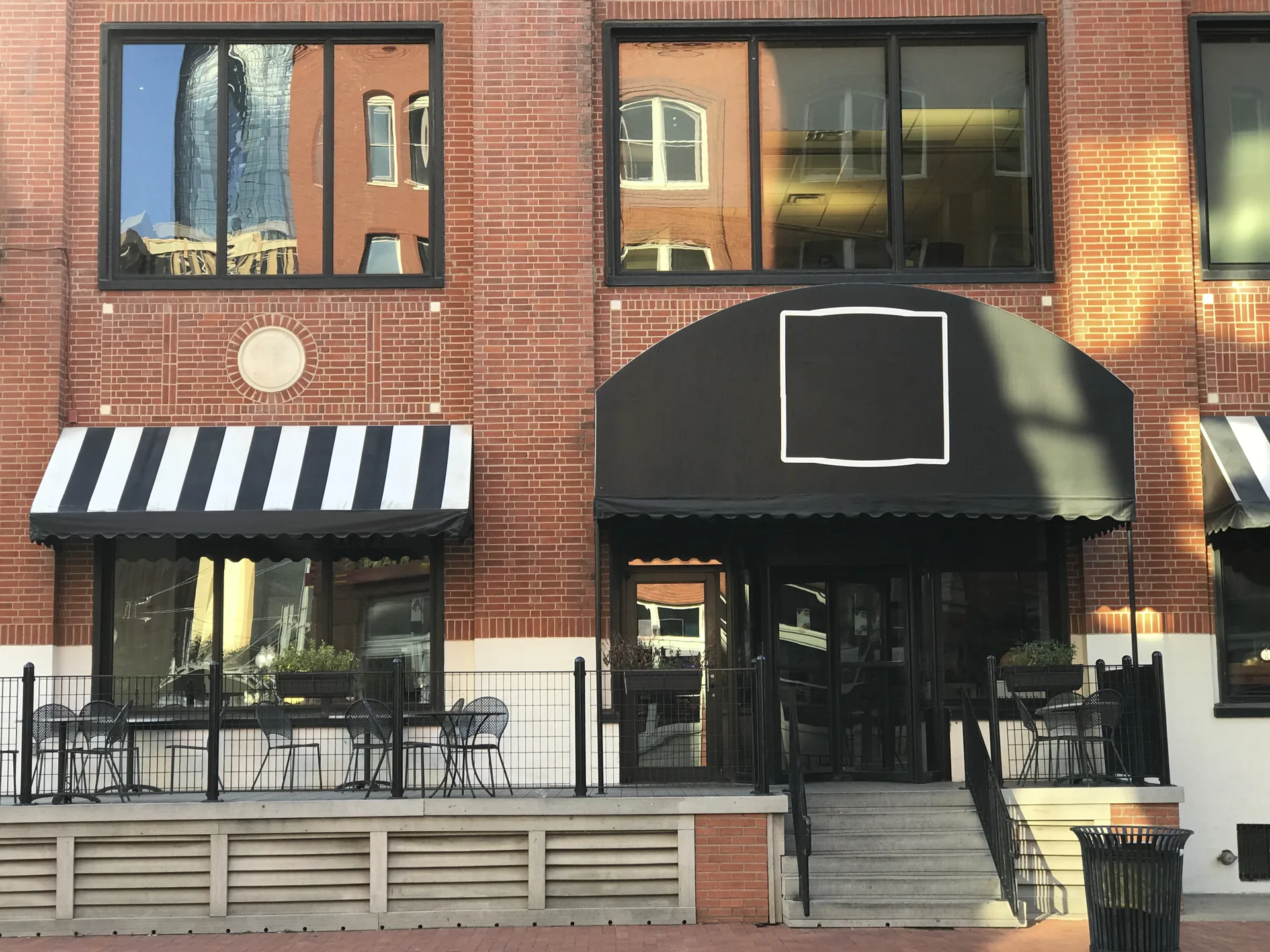 Downtown brick storefront with black awnings and large exterior windows