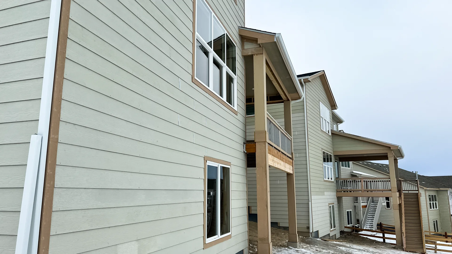 Clean residential siding, trim, and window detail on a multi-story exterior